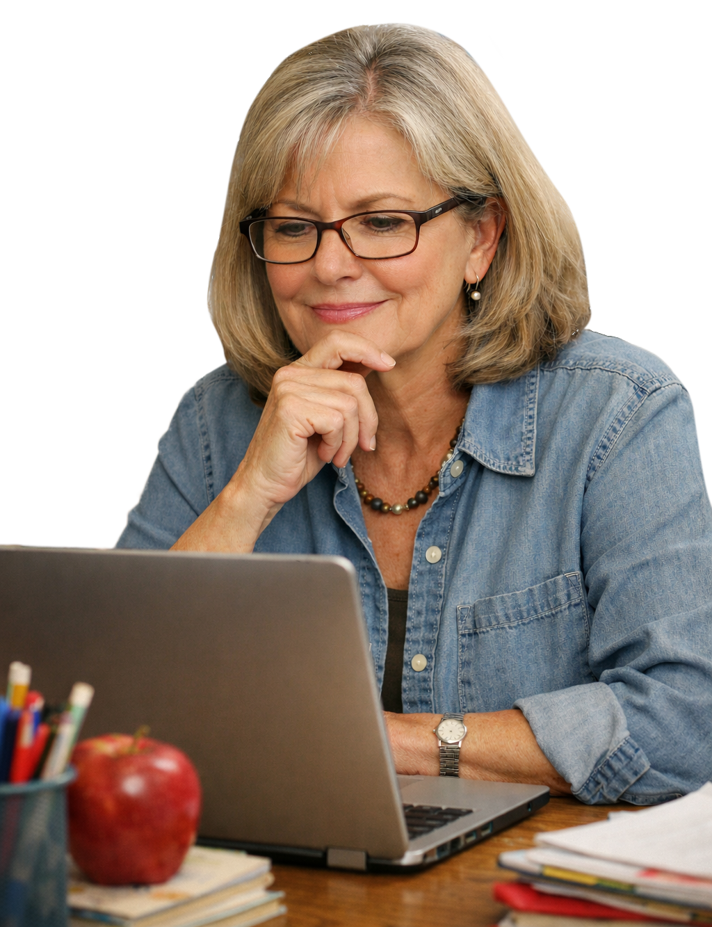 A teacher thoughtfully working at a laptop